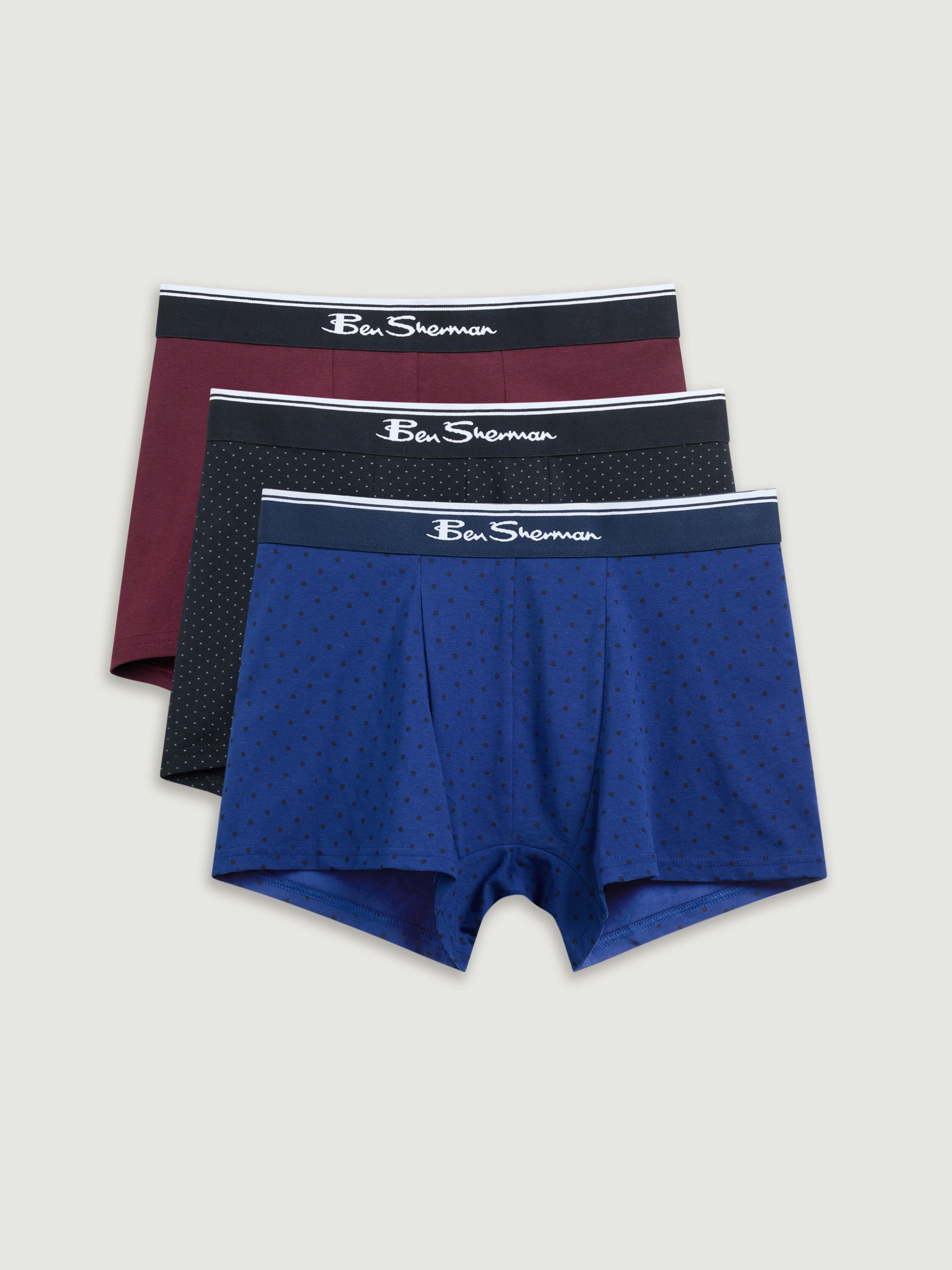 Three pairs of men's underwear with different colored waistbands on a light gray background.