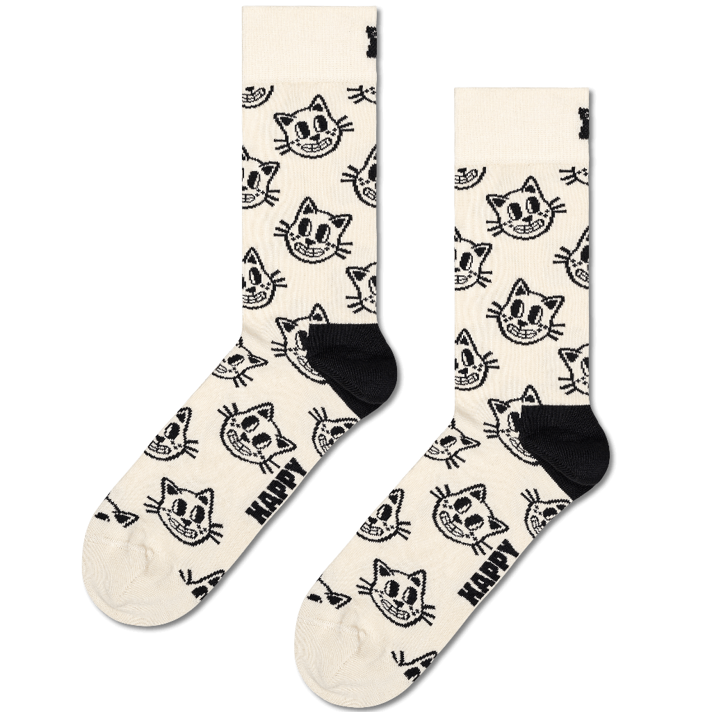 A pair of crew socks in cream with a black cartoon cat face pattern and the word 'HAPPY' printed near the foot, shown on a plain white background.