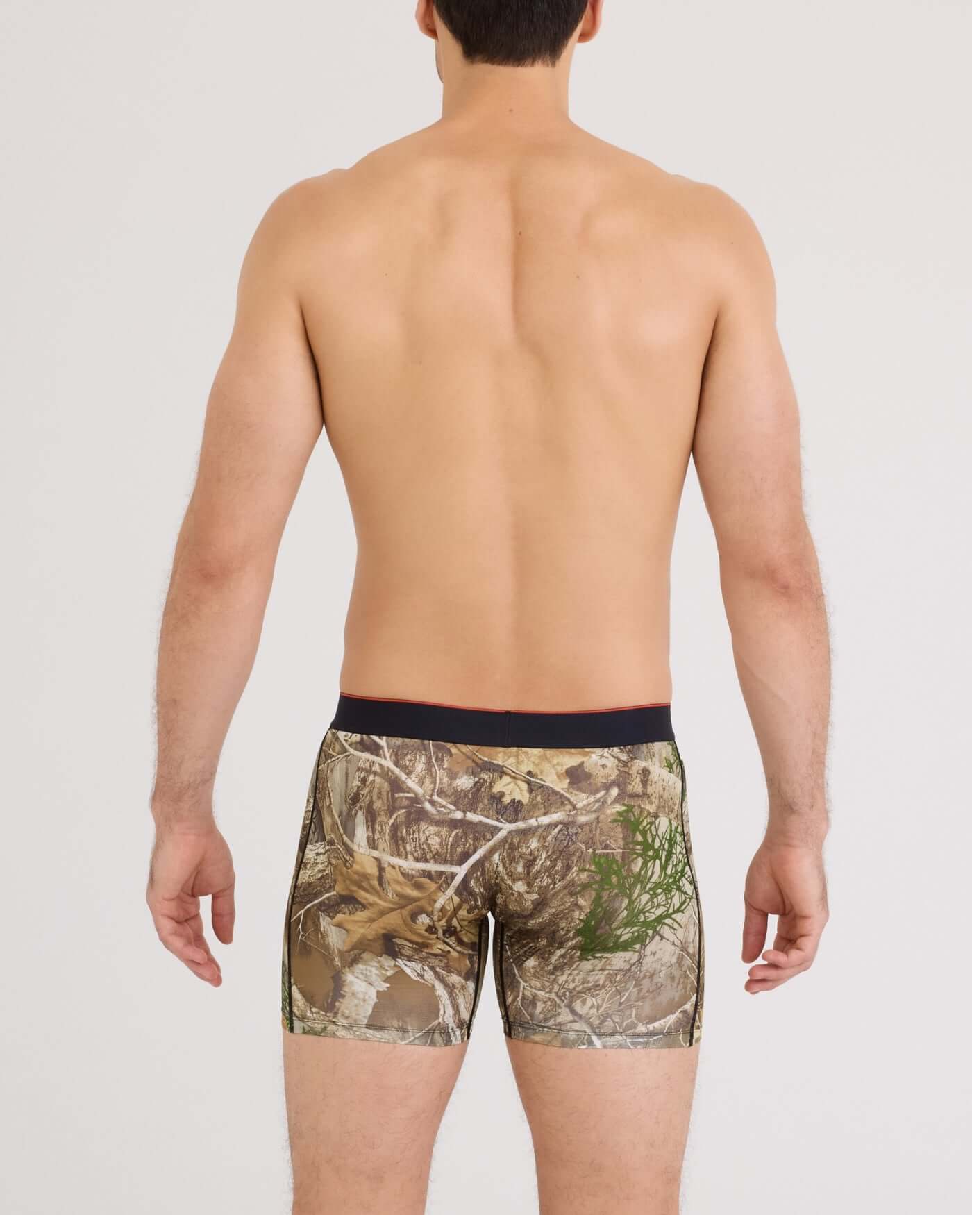 Man wearing camouflage boxer briefs on a plain background