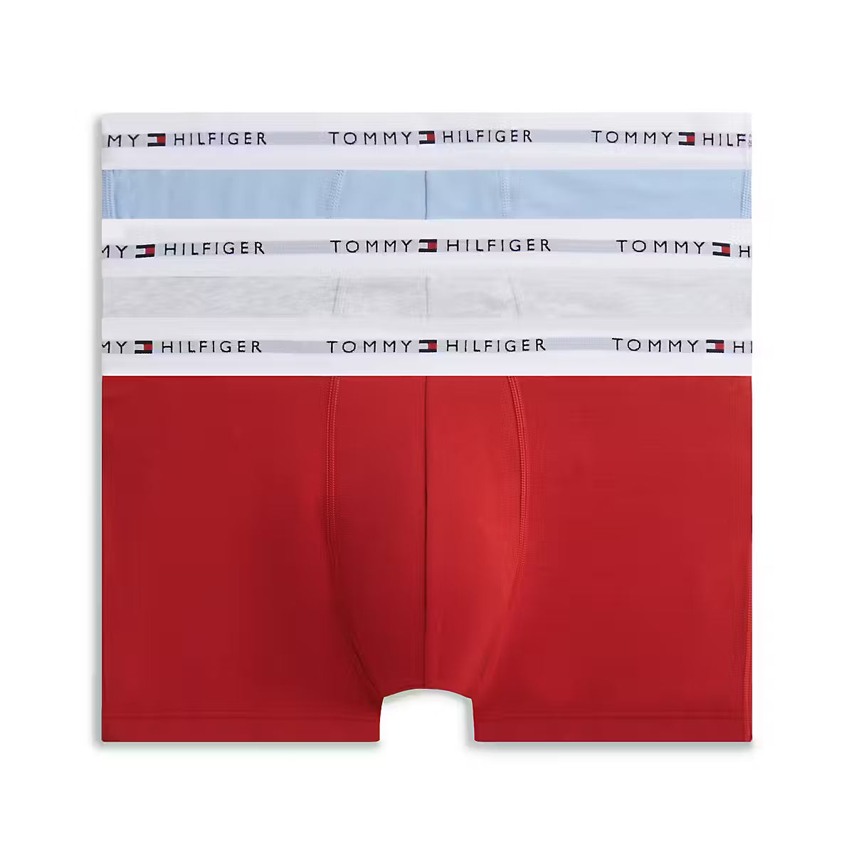A pair of Tommy Hilfiger men's boxer briefs featuring a distinctive color-blocked design with a solid red lower half and white and light blue upper panels, each with a white waistband printed with the Tommy Hilfiger logo.