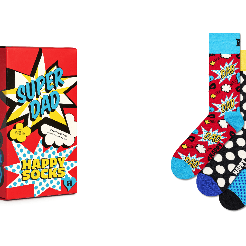 Happy Socks 'Super Dad' gift set featuring a red comic-book style box with 'SUPER DAD' and 'HAPPY SOCKS' text, alongside three colorful patterned socks with polka dots, stars, and comic burst designs on a white background.