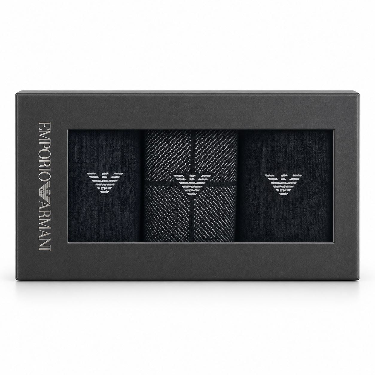 Emporio Armani 3-pack gift box containing black dress socks with silver embroidered eagle logos, shown in its black packaging on a white background.