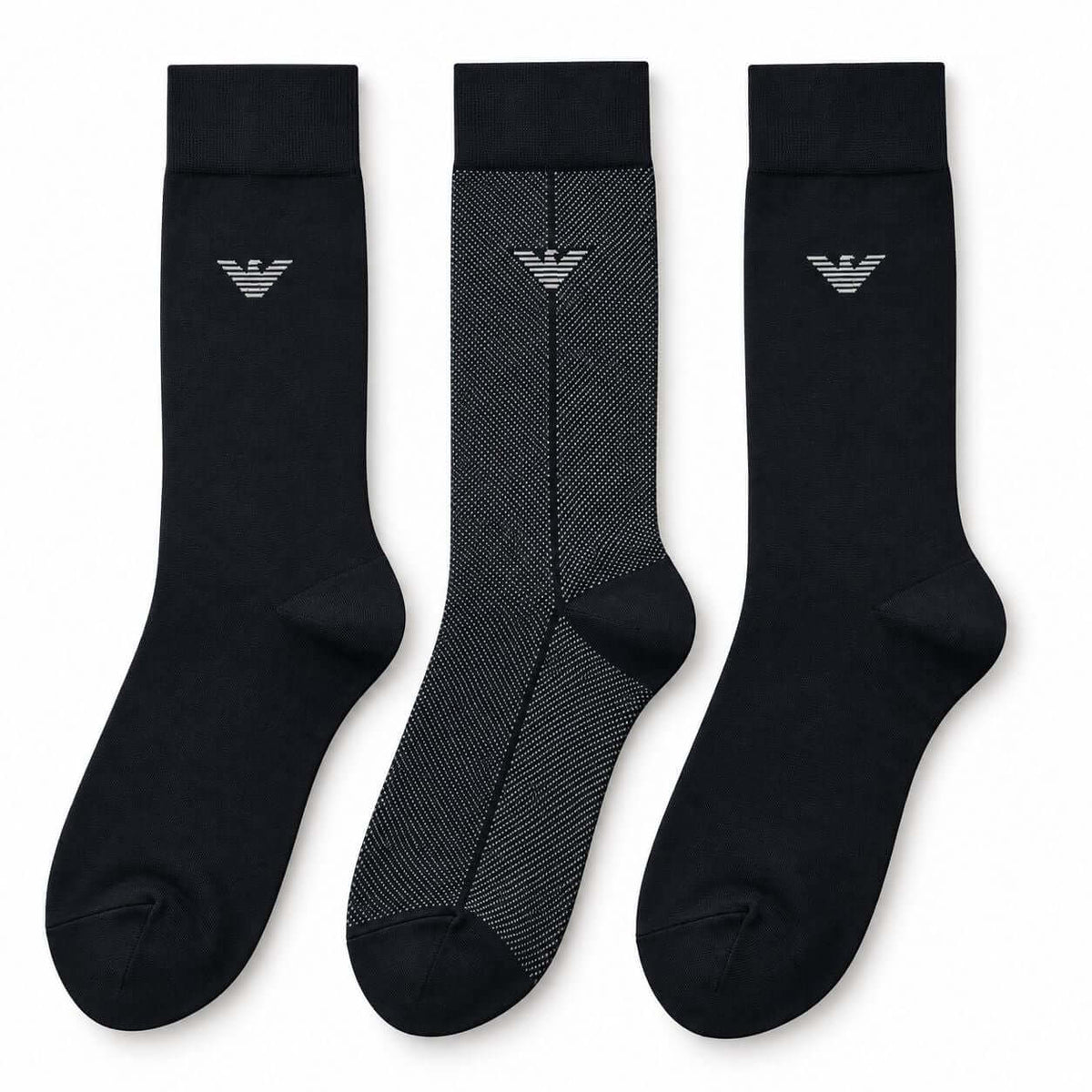 Three crew-length socks displayed side by side on a plain white background. Two socks are solid black with a small silver embroidered logo near the cuff, and one sock is black with a subtle gray herringbone pattern and a matching silver logo.