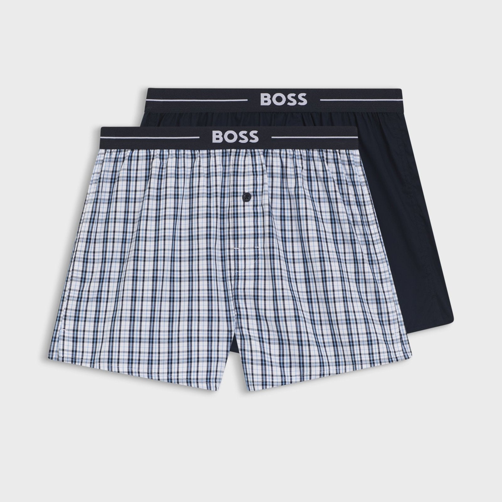 Two pairs of boxer shorts with a checkered pattern and black waistband on a white background, branded 'BOSS'.