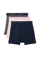 Three pairs of Calvin Klein boxer briefs in navy, pink, and black on a white background.
