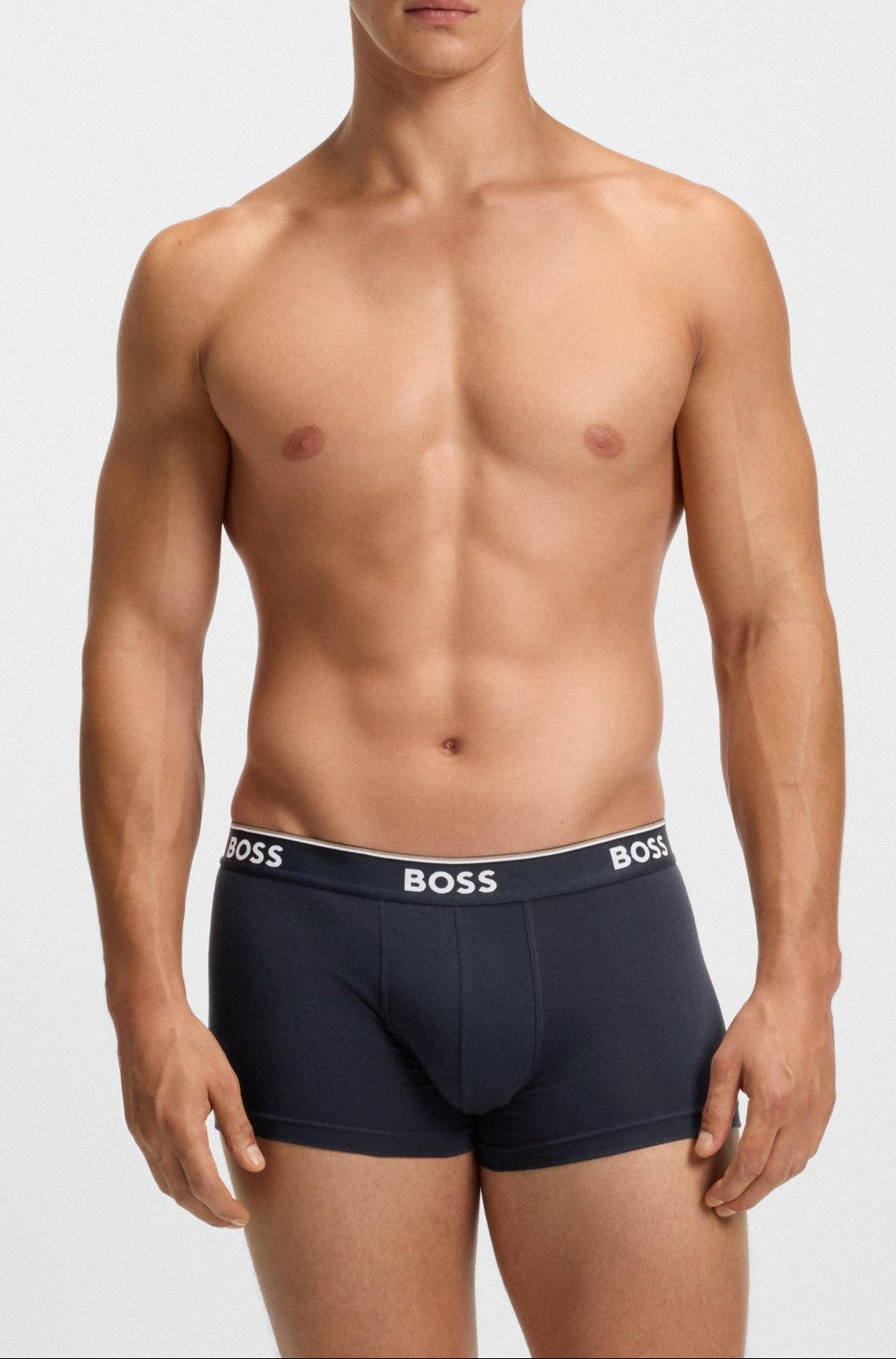 Man wearing navy blue BOSS underwear on a white background