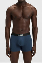 Man wearing blue underwear with a visible brand logo on a white background