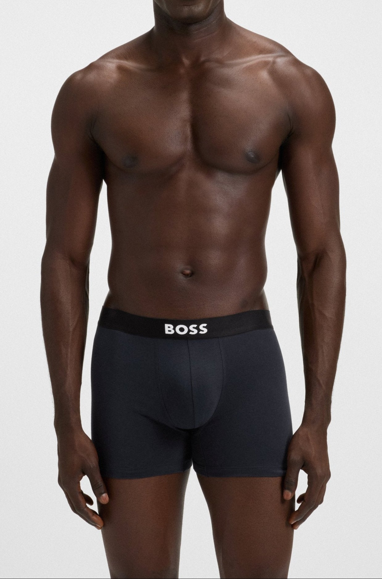 Man wearing black underwear with 'BOSS' branding on a white background