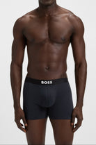 Man wearing black underwear with 'BOSS' branding on a white background