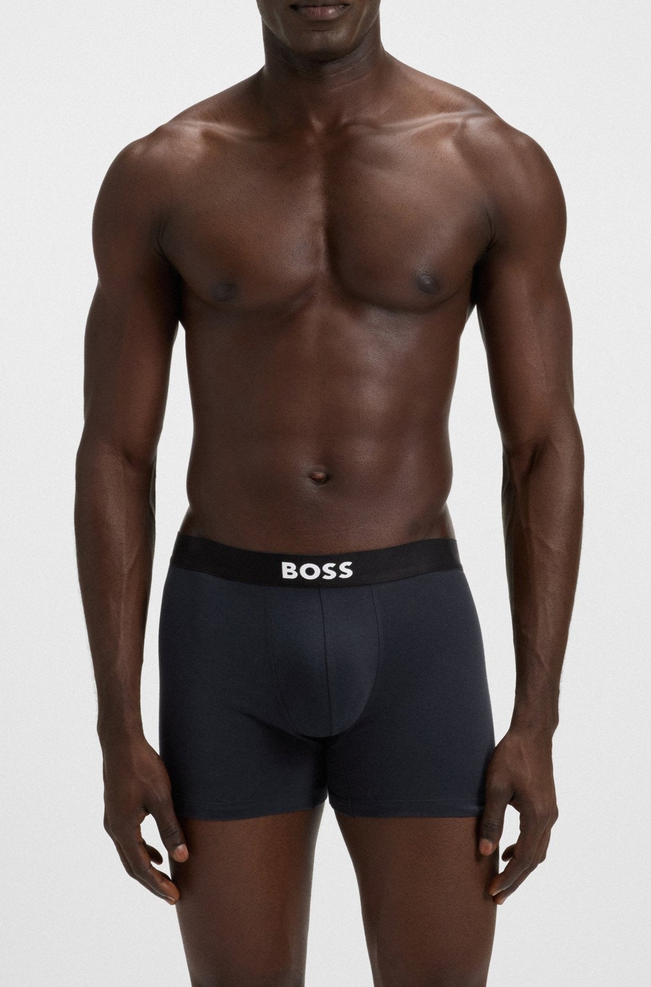 Man wearing black underwear with 'BOSS' branding on a white background