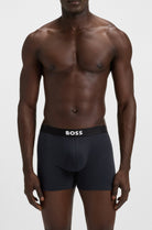 Man wearing black underwear with 'BOSS' branding on a white background