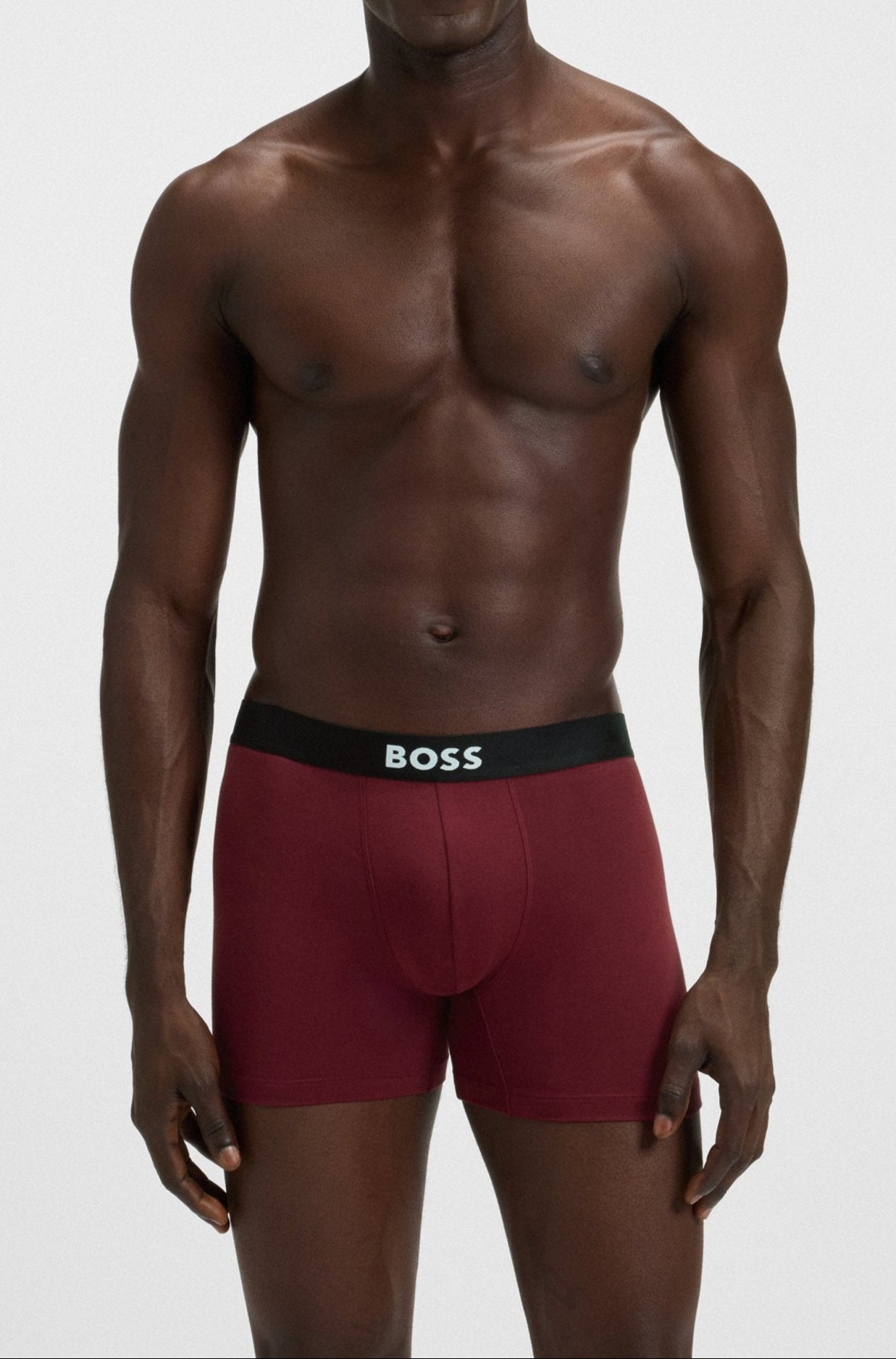 Man wearing red underwear with a visible brand logo on a white background