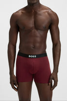 Man wearing red underwear with a visible brand logo on a white background