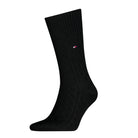 Black sock with a small red and white logo on a white background