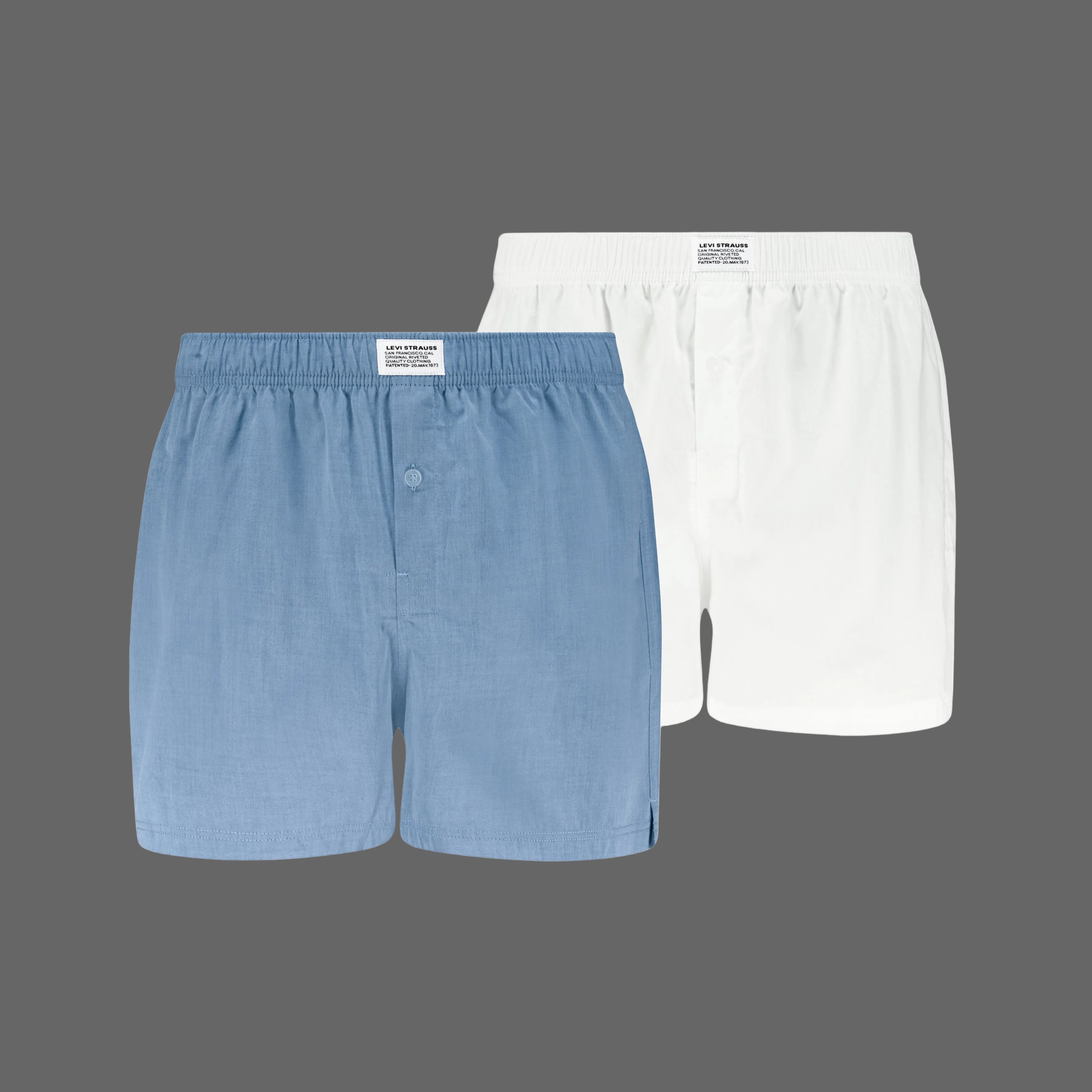 Two pairs of boxer shorts, one blue and one white, on a white background.