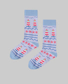 Pair of light blue socks with lighthouse design on a wooden surface, featuring the brand 'Polar Star'.