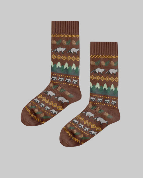 Pair of patterned socks with bears and trees on a wooden background, featuring the brand 'Polar Star'.
