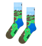 A pair of crew socks with a colorful golf course landscape print, featuring green fairways, blue water, brown sand bunkers, and cartoon golfers. The word 'HAPPY' is printed in black on the toes, and a small black logo is visible near the top cuffs.