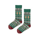 Green Christmas-themed socks with gingerbread design on a wooden surface, featuring the brand 'Polar Star'.