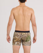 Man wearing camouflage boxer briefs on a plain background