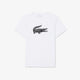 A white short-sleeve crewneck t-shirt featuring the signature Lacoste crocodile logo in black and white on the center chest, displayed flat against a light gray background.