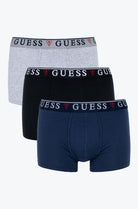Three pairs of Guess boxer briefs in gray, black, and navy on a white background.