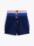 Navy blue boxer shorts with a red, white, and blue waistband on a light gray background