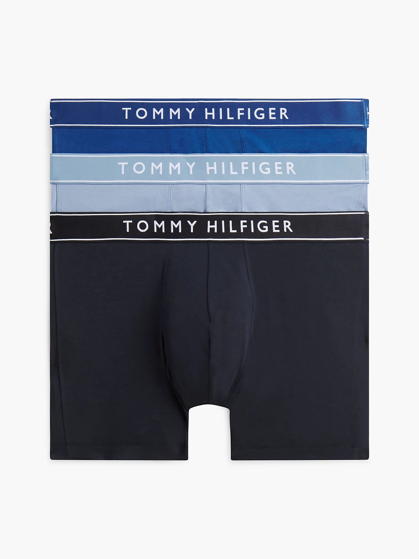 Three pairs of Tommy Hilfiger men's boxer briefs stacked vertically on a light gray background. The top pair is dark blue with white text, the middle pair is light blue with white text, and the bottom pair is black with white text.