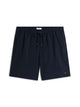 Navy blue drawstring shorts with a small Tommy Hilfiger flag logo on the lower left hem, displayed flat against a white background.