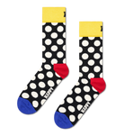 A pair of novelty crew socks with a black background, white polka dots, a bright yellow cuff, a red heel, and a blue toe. The word 'HAPPY' is printed in white on the foot.