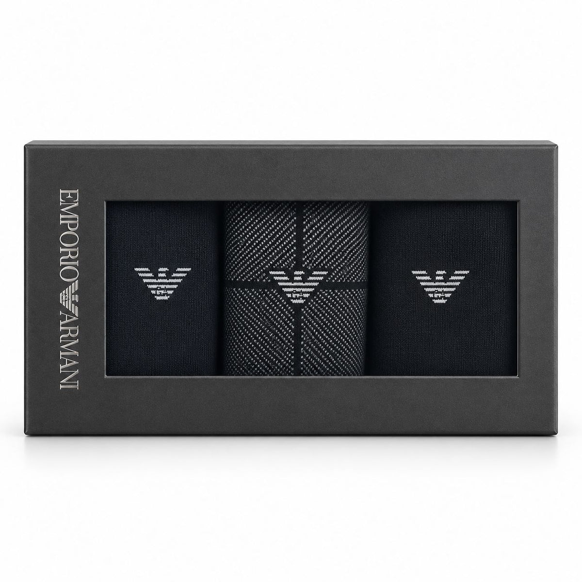 Emporio Armani 3-pack gift box containing black dress socks with silver embroidered eagle logos, shown in its black packaging on a white background.