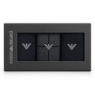 Emporio Armani 3-pack gift box containing black dress socks with silver embroidered eagle logos, shown in its black packaging on a white background.
