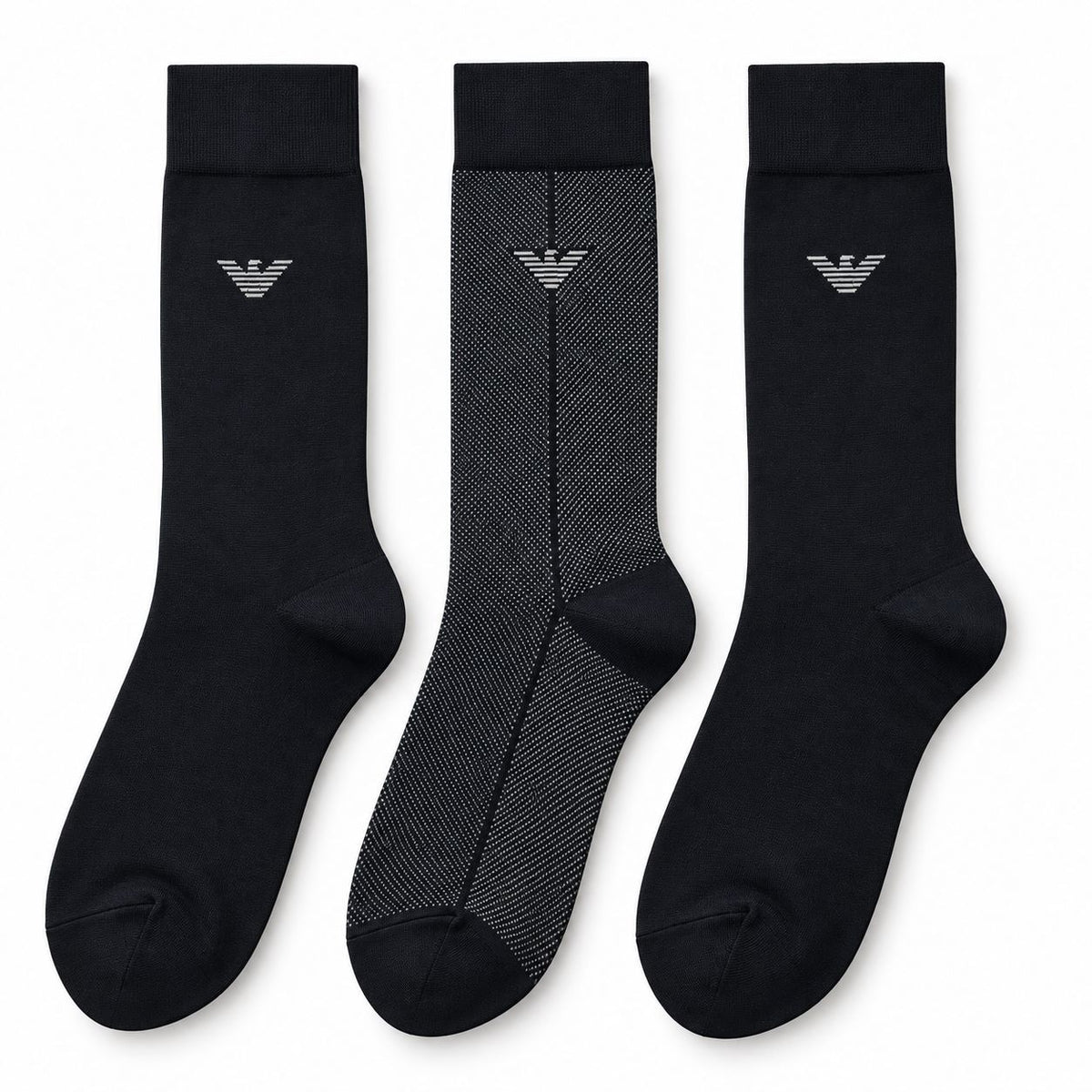 Three crew-length socks displayed side by side on a plain white background. Two socks are solid black with a small silver embroidered logo near the cuff, and one sock is black with a subtle gray herringbone pattern and a matching silver logo.