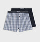Two pairs of boxer shorts with a checkered pattern and black waistband on a white background, branded 'BOSS'.