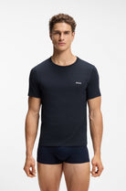 A male model wearing a dark navy blue short-sleeve crewneck t-shirt with a small white BOSS logo on the left chest, paired with matching navy boxer briefs, against a plain white studio background.