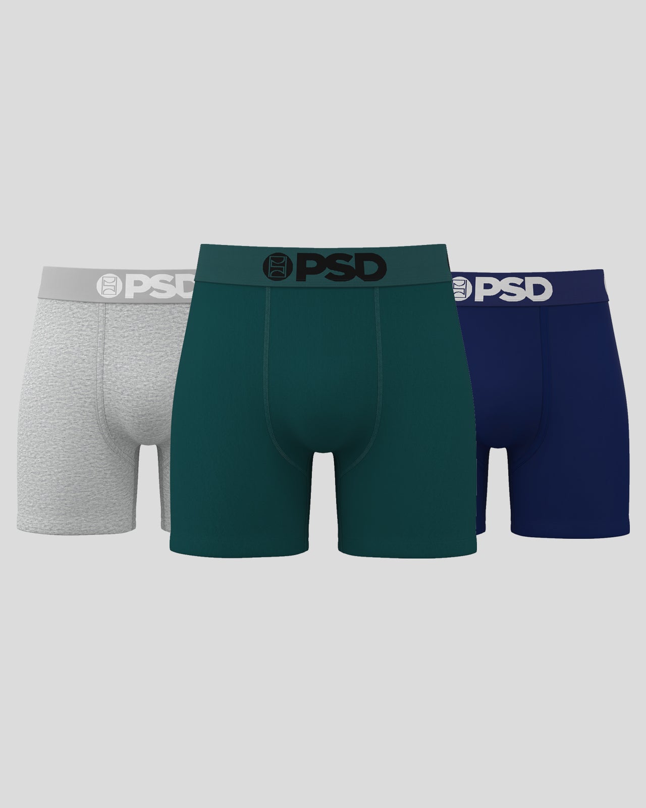 Three pairs of PSD boxer briefs in gray, green, and blue on a light gray background.
